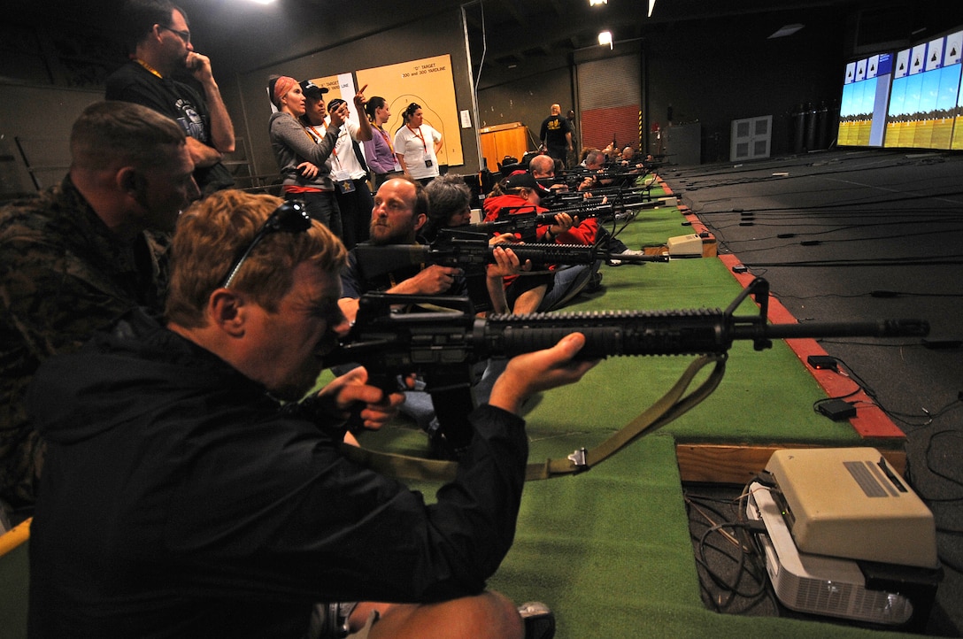 Curtis Ranweiler, a social studies teacher with Berthound High School, Berthound, Colo., aims at a simulated target inside the Indoor Simulated Marksmanship Trainer on March 3 at the Weapons Field Training Battalion, Marine Corps Base Camp Pendleton, Calif. Each year educators throughout the 10 states, which make up the 8th Marine Corps District, participate in the Educators Workshop, a five day event in Southern Calif. which allows high school teachers to experience Marine Corps recruit training.